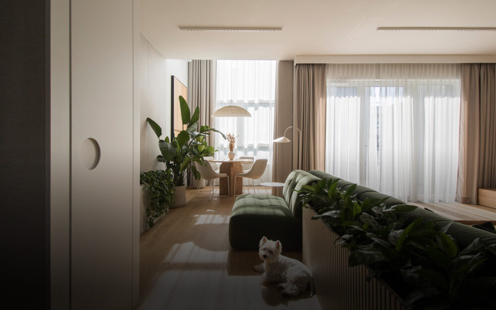 Projekt wnętrza – nowoczesny salon w dwupoziomowym apartamencie, minimalistyczny styl z drewnianymi elementami, zielonymi detalami i roślinami we wnętrzu