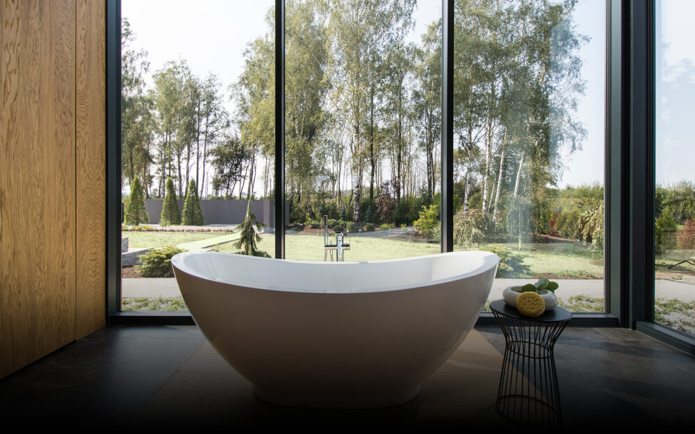 Nowoczesny salon z drewnianymi i betonowymi ścianami oraz kamienną posadzką, projekt TK Architekci.